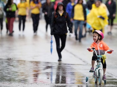 A girl tries to catch raindrops with her tongue during the 26th annual Cruisin' Down the Crescent fundraising event for the Rehabilitation Centre for Children on Wellington Crescent in Winnipeg on Sunday, June 12, 2022. Returning from a two-year break due to the COVID-19 pandemic, the event supports programs, equipment, technology and research for children and youth living with physical and developmental disabilities.