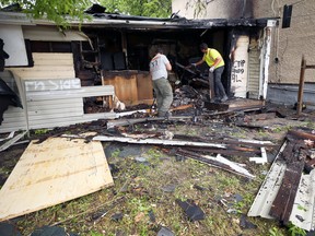 A crew works at the rear of a vacant house in the 300 block of College Avenue in Winnipeg expected to be a total loss after a fire in the morning of Tuesday, June 14, 2022. Three firefighters were injured battling the blaze.