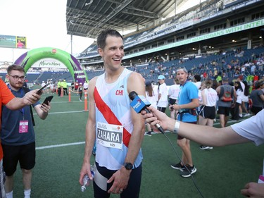 Michael Zahara speaks with media after being the first to cross the finish line during the Manitoba Marathon at IG Field in Winnipeg on Sunday, June 19, 2022.