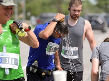 Runners cool off on Pembina Highway during the Manitoba Marathon in Winnipeg on Sunday, June 19, 2022.