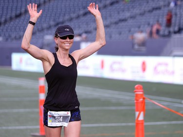 Dawn Neal crosses the finish line at IG Field as the female full marathon winner (unofficial) at the Manitoba Marathon in Winnipeg on Sunday, June 19, 2022.