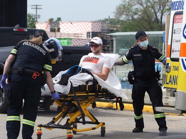 A runner is loaded into an ambulance along Pembina Highway north of Point Road during the Manitoba Marathon in Winnipeg on Sunday, June 19, 2022.