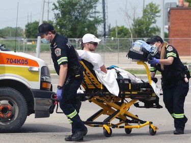A runner is loaded into an ambulance along Pembina Highway north of Point Road during the Manitoba Marathon in Winnipeg on Sunday, June 19, 2022.