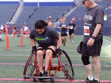 A wheelchair competitor pushes over the finish line, after struggling on the artificial turf, during the Manitoba Marathon in Winnipeg on Sun., June 19, 2022. KEVIN KING/Winnipeg Sun/Postmedia Network