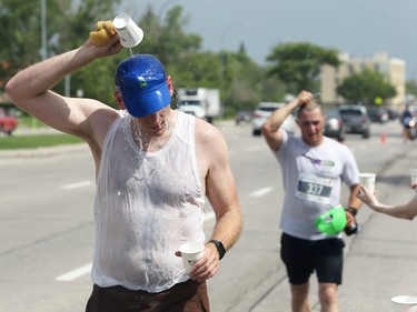 A man douses himself with water on Pembina Highway during the Manitoba Marathon in Winnipeg on Sun., June 19, 2022. KEVIN KING/Winnipeg Sun/Postmedia Network