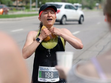 A woman feels the relief from cold water on Pembina Highway during the Manitoba Marathon in Winnipeg on Sun., June 19, 2022. KEVIN KING/Winnipeg Sun/Postmedia Network