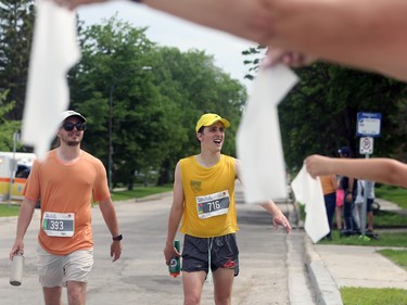 Supporters offer damp paper towels to participants in the Manitoba Marathon along Point Road in Winnipeg on Sun., June 19, 2022. KEVIN KING/Winnipeg Sun/Postmedia Network