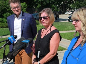 Dianna Klassen (centre) speaks as Manitoba Liberal leader Dougald Lamont (left) and Gail Johnson (right) look on during a news conference outside the Manitoba Legislature on Tuesday, July 12.