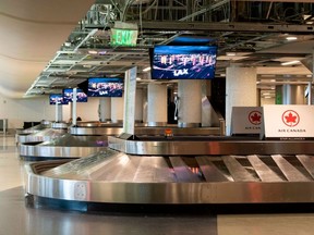 Air Canada signs are seen at the empty baggage claim area of Terminal 5 at Los Angeles International Airport (LAX) during the outbreak of the novel coronavirus, which causes COVID-19, April 16, 2020, in Los Angeles. (Photo by VALERIE MACON/AFP via Getty Images)