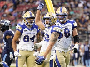 Winnipeg Blue Bombers' Drew Wolitarsky celebrates his touchdown with teammates Geoff Gray (right) and Brendan O'Leary-Orange during the first half against the Toronto Argonauts on Monday at BMO Field.