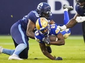 Winnipeg Blue Bombers' Greg McCrae is tackled by Toronto Argonauts' Ja'Gared Davis during the first half of CFL football action in Toronto, Monday, July 4, 2022.