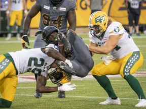 Hamilton Tiger Cats defensive back Lawrence Woods (37) is tackled by Edmonton Elks defensive back Mike Dubuisson (29)and Ante Milanovic-Litre (34) during first half CFL football game action in Hamilton, Ont., on Friday, July 1, 2022.