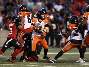 BC Lions quarterback Nathan Rourke (12) gets sacked by Ottawa Redblacks defensive lineman Praise Martin-Oguike (95) during first half CFL football action in Ottawa on Thursday, June 30, 2022.