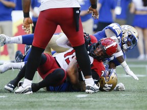 Winnipeg Blue Bombers' Willie Jefferson (5) sacks Calgary Stampeders quarterback Bo Levi Mitchell (19) during the first half of CFL action in Winnipeg, Friday, July 15, 2022.