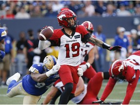 Winnipeg Blue Bombers' Jackson Jeffcoat (94) gets a hold of Calgary Stampeders quarterback Bo Levi Mitchell (19) as he throws during the first half of CFL action in Winnipeg, Friday, July 15, 2022.