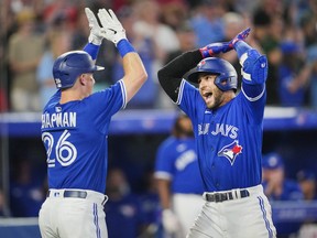 George Springer, right, of the Toronto Blue Jays celebrates his grand slam with Matt Chapman against the St. Louis Cardinals in the sixth inning during their MLB game at the Rogers Centre on July 26, 2022 in Toronto.