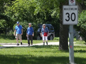 People use a path along a road with a reduced traffic speed in Winnipeg on Thursday, June 30, 2022