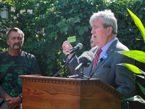 Winnipeg mayoral candidate Glen Murray holds up a “Powerline” card during a campaign stop at the William Whyte Community Garden on Burrows Avenue on Friday, Aug. 26.