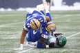 Winnipeg Blue Bombers defensive ends Jackson Jeffcoat (top) and Willie Jefferson pile on Saskatchewan Roughriders QB Cody Fajardo.