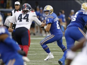 Winnipeg Blue Bombers quarterback Zach Collaros looks down field as he gets pressure from Montreal Alouettes defensive lineman Mike Moore last night. John Woods/THE CANADIAN PRESS