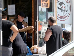 People receive food aid from the Bear Clan Patrol food bank in Winnipeg on Wednesday, Aug. 3, 2022.