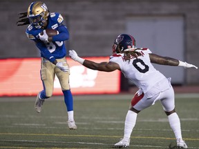 Winnipeg Blue Bombers wide receiver Janarion Grant leaps to avoid a tackle from Montreal Alouettes linebacker Brian Harelimana during second quarter CFL football action in Montreal on Thursday, August 4, 2022.