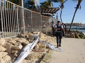 In this file photo, Mexican police agents, investigate at a nightclub near the beach in Playa del Carmen, Quintana Ro state, Mexico where 5 people were killed, three of them foreigners, during a music festival on Jan. 16, 2017.