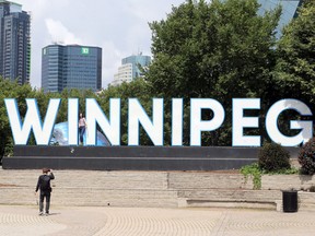 People take pictures at the Winnipeg sign at The Forks on Monday, Aug. 1, 2022.