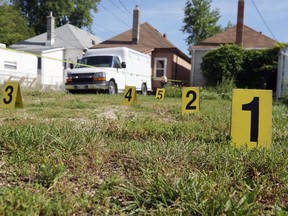 Evidence markers are pictured in the rear yard of a home in the 600 block of Cathedral Avenue in Winnipeg on Wed., Aug. 17, 2022. Police found a deceased adult male inside the home Tuesday at about 3 p.m., and believe his death to be a homicide. KEVIN KING/Winnipeg Sun/Postmedia Network