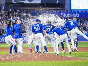 Teammates splash Vladimir Guerrero Jr. #27 of the Toronto Blue Jays with water after his walk-off hit to defeat the New York Yankees in the tenth inning during their MLB game at the Rogers Centre on September 26, 2022 in Toronto. (Photo by Mark Blinch/Getty Images)