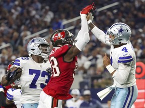 Dallas Cowboys quarterback Dak Prescott (4) hits his hand against Tampa Bay Buccaneers linebacker Shaquil Barrett (58) while throwing.