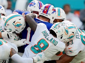 Josh Allen of the Buffalo Bills is gang-tackled by the Miami Dolphins defence during the fourth quarter at Hard Rock Stadium on September 25, 2022 in Miami Gardens, Florida.