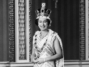 Britain's Queen Elizabeth II, dressed in royal regalia, posed for this special Jubilee picture in the Throne Room of Buckingham Palace, after she had delivered the traditional Queen's speech at the 1976 official State Opening of Parliament. She wears the Imperial State Crown and the Robe of State, also known as the Parliamentary Robe. Around her neck is the Jubilee Necklace of diamonds and pearls and the chain is the Collar of the Order of the Garter, Britain's premier order of Knighthood. Her gown is of white silk with bands of gold and silver embroidery. (Photo by - / AFP) (Photo by -/AFP via Getty Images)