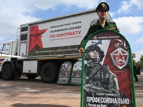 A Russian service member stands next to a mobile recruitment center for military service. Sept. 17, 2022. REUTERS/Sergey Pivovarov