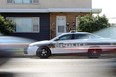 Traffic goes past a police cruiser sitting in front of a duplex on Logan Avenue near McPhillips Street in Winnipeg on Mon., Sept. 5, 2022.