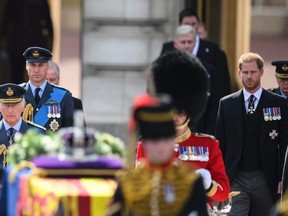 King Charles III, Prince William, Prince of Wales and Prince Harry, Duke of Sussex walk behind the gun carriage bearing the coffin of the late Queen Elizabeth II as it departs Buckingham Palace, transferring the coffin to The Palace of Westminster, in London, Wednesday, Sept. 14, 2022.