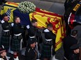 Pallbearers carry the coffin of Britain's Queen Elizabeth, as the hearse arrives at St. Giles' Cathedral, in Edinburgh, Scotland, Britain September 12, 2022. REUTERS/Russell Cheyne