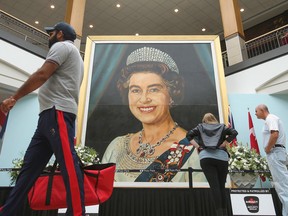 Shoppers walk past a five-meter-high image of  Queen Elizabeth II, painted by billboard artist Gilbert Burch in 1979, at CF Polo Park in Winnipeg on Sept; 17, 2022.