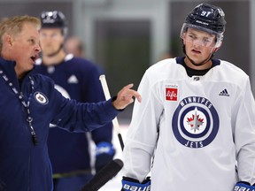 Cole Perfetti (right) listens as Manitoba Moose head coach Mark Morrison speaks during a Winnipeg Jets Young Stars tournament team workout at Bell MTS Iceplex on Wednesday.