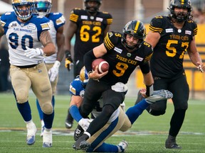 Hamilton Tiger Cats quarterback Dane Evans (9) keeps the ball and runs for a first down during second half CFL football game action against the Winnipeg Blue Bombers in Hamilton, Ont. on Saturday, September 17, 2022.
