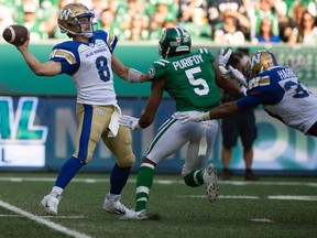 Winnipeg Blue Bombers quarterback Zach Collaros (8) looks to pass while being run down by Saskatchewan Roughriders defensive back Loucheiz Purifoy (5) during last year's Labour Day Classic at Mosaic Stadium in Regina.