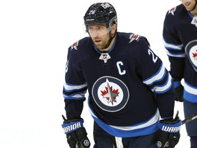 Winnipeg Jets forward Blake Wheeler (left) heads to the bench to celebrate after scoring against the Colorado Avalanche in Winnipeg on Sunday, April 24, 2022.