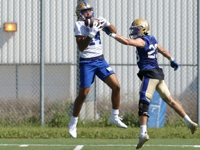 Winnipeg Blue Bombers receiver Jaivon Heiligh pulls a catch down in front of defensive back Noah Hallett during practice on Thursday, Sept. 1, 2022.