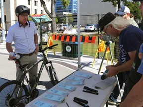 Mayoral candidate Scott Gillingham (left) uses the bike valet at ManyFest street festival in downtown Winnipeg on Sunday, Sept. 11, 2022.