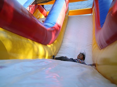 A boy whips down a slide in a bouncy castle at the ManyFest in downtown Winnipeg on Sunday, Sept. 11, 2022. The street festival returned after a two-year absence due to COVID-19.