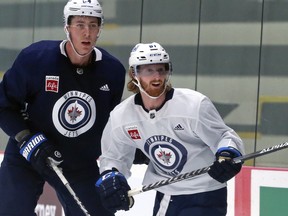 Kyle Connor (right) and Logan Stanley come together as the Winnipeg Jets opened training camp at Bell MTS Iceplex on Thursday, Sept. 22, 2022. Stanley returns to the lineup tonight after missing six weeks with a broken ankle.