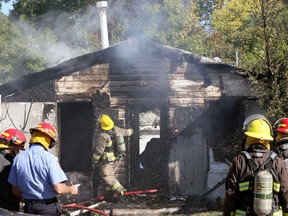 Firefighters battle a flareup at a house on Union Avenue West in Winnipeg on Sunday, Sept. 25, 2022. A fire broke out at the home at about 8 a.m., with firefighters returning at about 11:30 a.m. after it reignited.