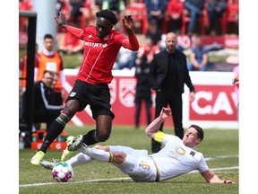 Cavalry FC Jean-Aniel Assi (L) is tackled along the sidelines by Valour Daryl Fordyce during CPL soccer action between Cavalry FC and Valour FC at ATCO Field at Spruce Meadows in Calgary on Saturday, May 21, 2022.