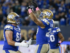 Winnipeg Blue Bombers' Geoff Gray (left) and Brady Oliveira celebrate Oliveira's touchdown against the Edmonton Elks during the first half in Winnipeg on Saturday.