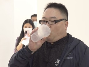 In this photo taken from video released by Shanghai Media Group, a man inhales aerosolized COVID vaccine developed by Chinese biopharmaceutical company CanSino Biologics Inc. in Shanghai on Wednesday, Oct. 26, 2022.